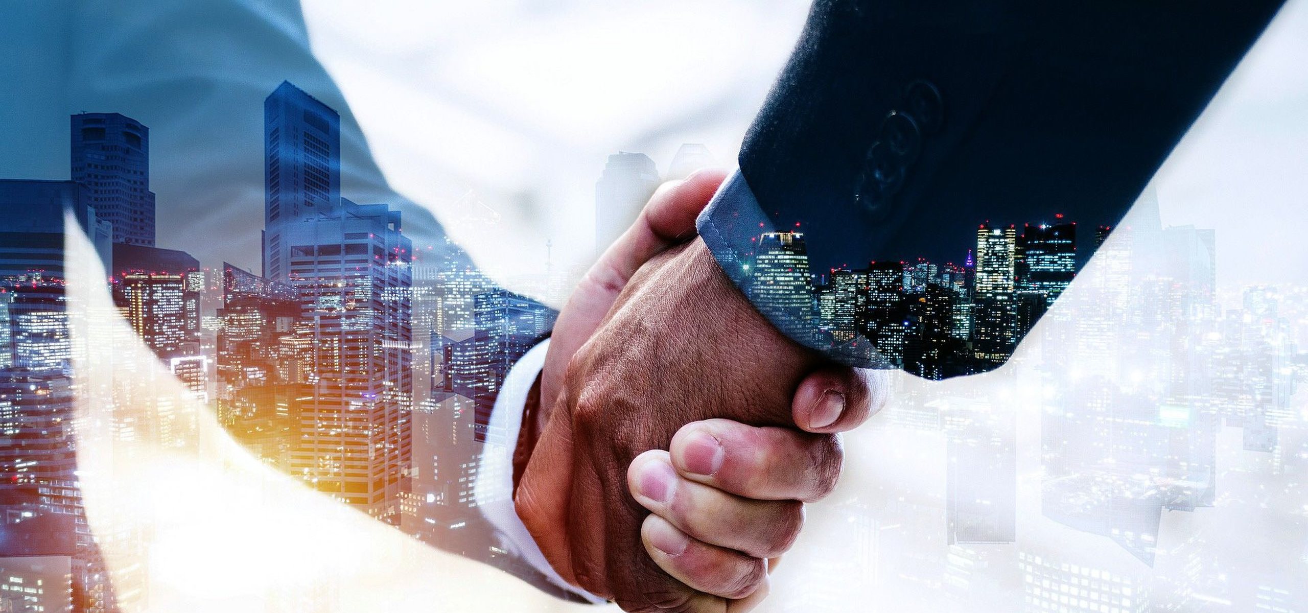 Double-exposure handshake over a city skyline at night